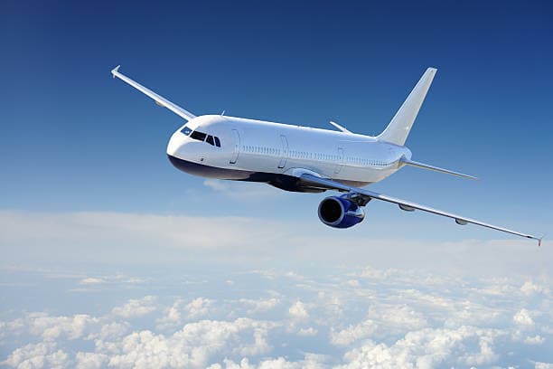 Airplane flying through a blue night sky