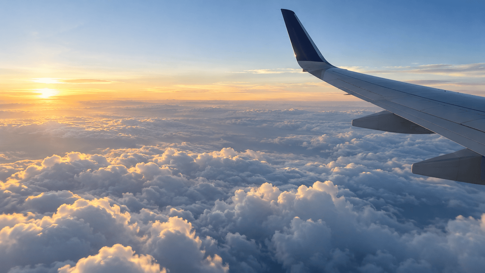 Airplane cruising above bright clouds